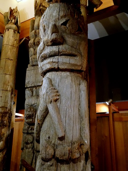 Mortuary pole of human holding a club